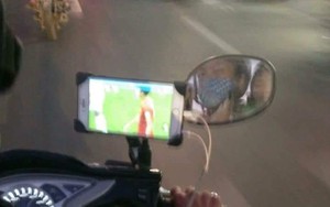 Vừa lái xe vừa dùng điện thoại xem Việt Nam đá, tài xế xe ôm khiến nhiều người lo lắng