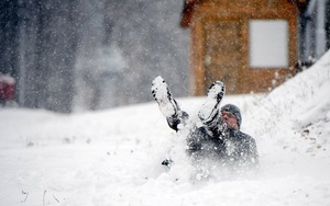 24h qua ảnh: Người đàn ông thích thú chơi đùa với tuyết rơi đầu mùa