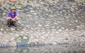 Người dân thư thả ngồi câu cá bên bờ sông Tô Lịch