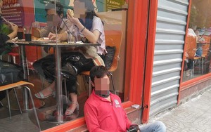 Bức ảnh thanh niên ngủ ngồi, tựa vào bậc cửa quán ăn khiến dân mạng chia phe tranh cãi