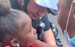 Cảm động hình ảnh chú cảnh sát ôm lấy bé gái da màu đang òa khóc giữa biểu tình sau khi nhận được câu hỏi gây ám ảnh