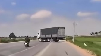 Video: Thanh niên chạy xe máy trượt ngã vào gầm ô tô tải đang quay đầu