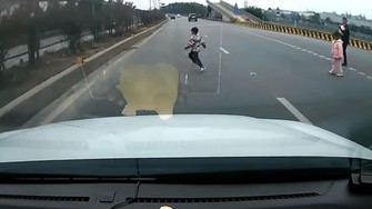 Clip: Ô tô phanh gấp, tránh em bé chạy băng qua đường Quốc lộ