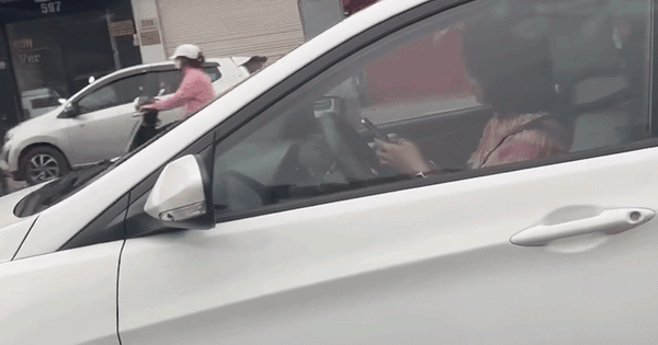 Nữ tài xế dùng 2 tay bấm điện thoại trong lúc đang lái xe trên phố Hà Nội