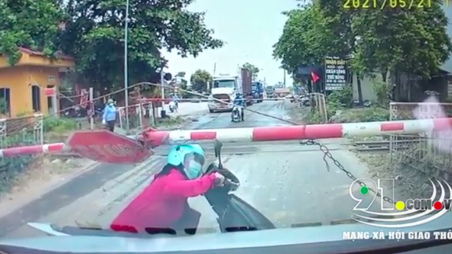 Vội về nhà, người phụ nữ chật vật chui qua thanh chắn barie mặc đoàn tàu đang lao tới