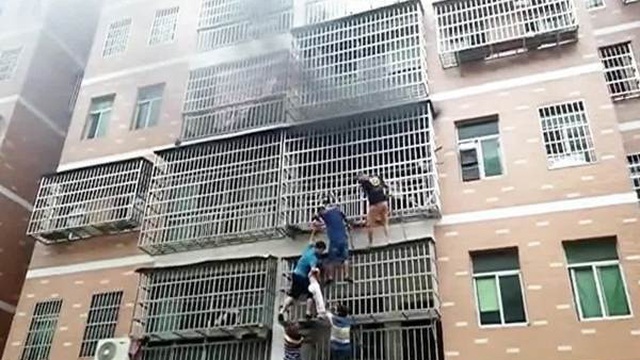 Sáu người đu bám ngoài chuồng cọp giải cứu 2 bé gái trong căn nhà cháy
