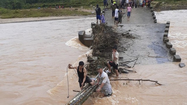 Lũ lớn đánh sập cầu độc đạo, dân lấy cây bắc cầu tạm qua sông