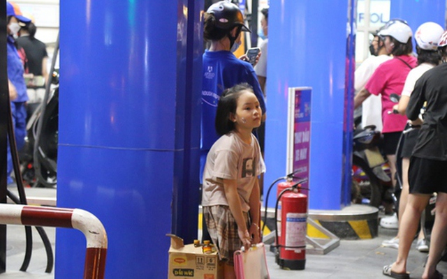Trẻ em vạ vật chờ cha mẹ xếp hàng mua xăng lúc nửa đêm