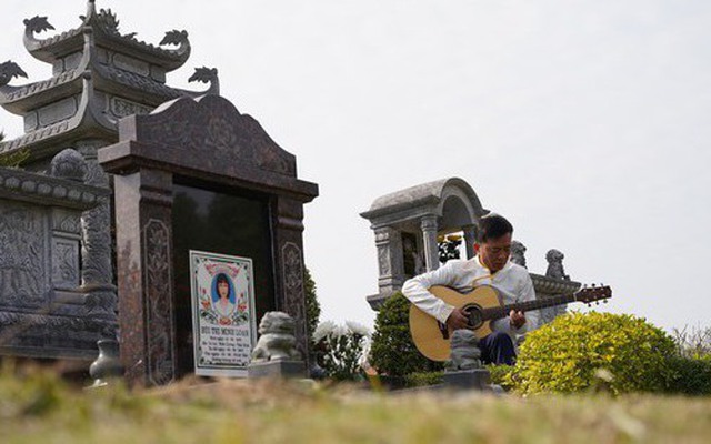 Người đàn ông ngồi hát bên mộ vợ trong lễ tạ mộ ngày cuối năm