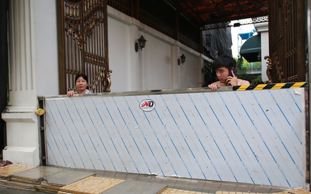 Trời hửng nắng, nhiều tuyến đường ở Hà Nội vẫn ngập sâu, người dân dùng tấm chắn để ngăn nước tràn vào nhà