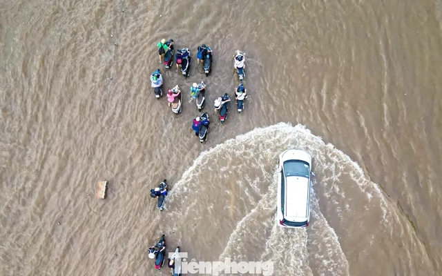 Xe máy ‘rẽ sóng’ giữa phố, tìm đường lên cao tốc tránh ngập tại Hà Nội