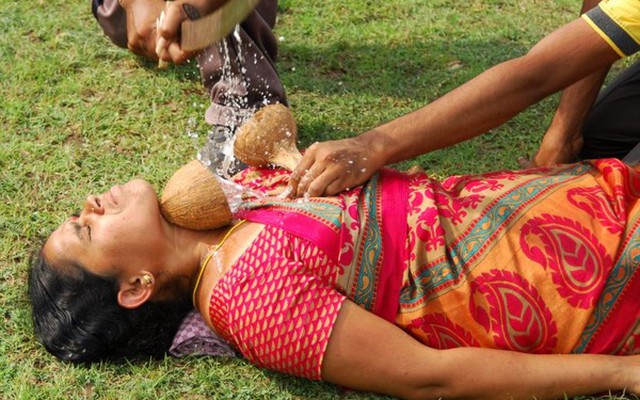 Người phụ nữ gan dạ biểu diễn màn chém dừa trên cổ họng