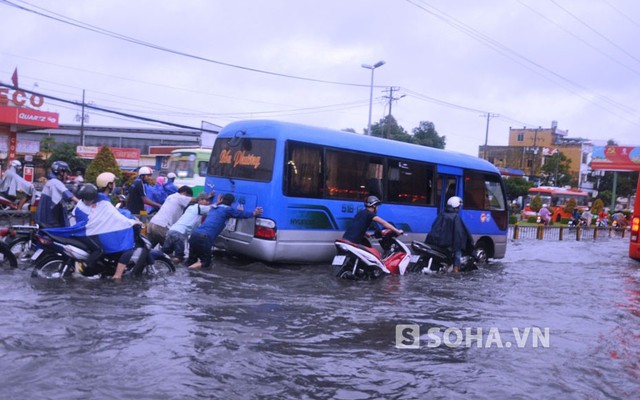 Người dân hì hục đẩy ô tô giữa dòng nước ngập ở TPHCM