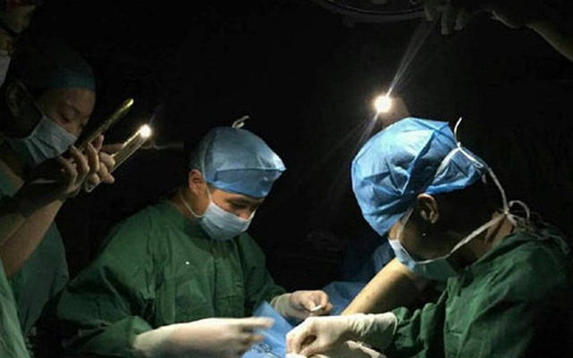 Bức ảnh bác sĩ phẫu thuật dưới ánh đèn điện thoại lay động trái tim