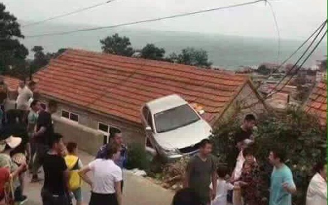 Hình ảnh lạ gây tranh cãi: Xe ô tô mắc kẹt trên nóc nhà