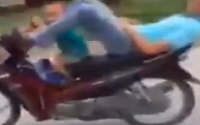 Clip: Người đàn ông nằm ngửa lái xe máy, kẹp đứa bé ở phía trước