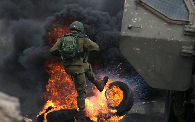 7 ngày qua ảnh: Lính Israel đá lốp xe cháy rực lửa trong cuộc đụng độ với người Palestine