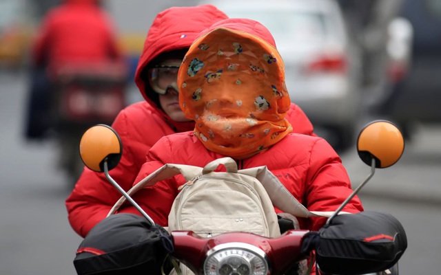 24h qua ảnh: Người Trung Quốc bịt kín mặt đi xe máy để chống lạnh và ô nhiễm