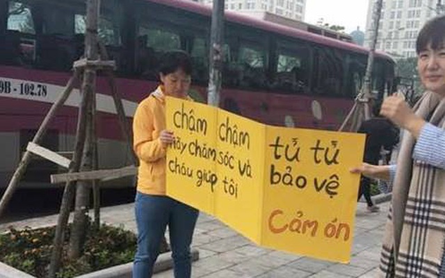 Bà mẹ Hàn Quốc cầm biển "xin" người dân không đi lên vỉa hè tại Hà Nội