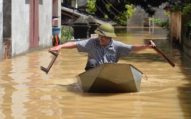 Chùm ảnh: Nhà ngập sâu đến ngang cửa, người dân Ninh Bình dùng chậu nhôm, ghế gỗ chèo thuyền đi lại trong ngõ