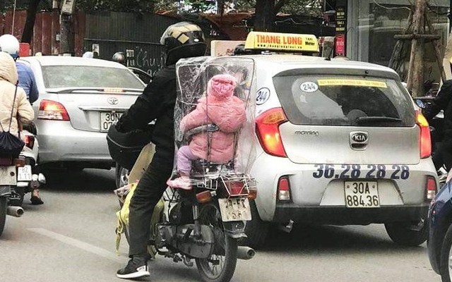 Hình ảnh cha chụp túi giữ ấm cho con trong ngày Hà Nội chuyển rét khiến nhiều người cay mắt
