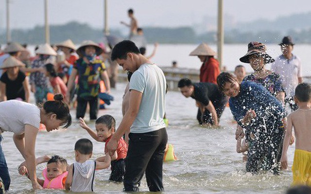 Chùm ảnh: Người lớn, trẻ nhỏ Hà Nội mặc áo phao ùa ra đường tỉnh lộ bơi lội, đánh cá sau nhiều ngày mưa ngập