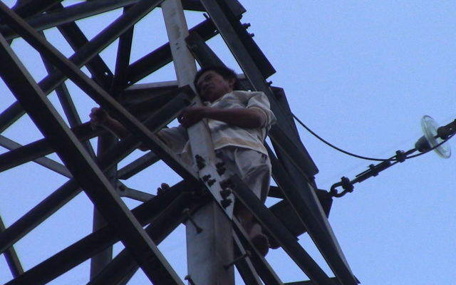 Người đàn ông trèo lên đỉnh trụ điện cao thế rồi múa và la hét