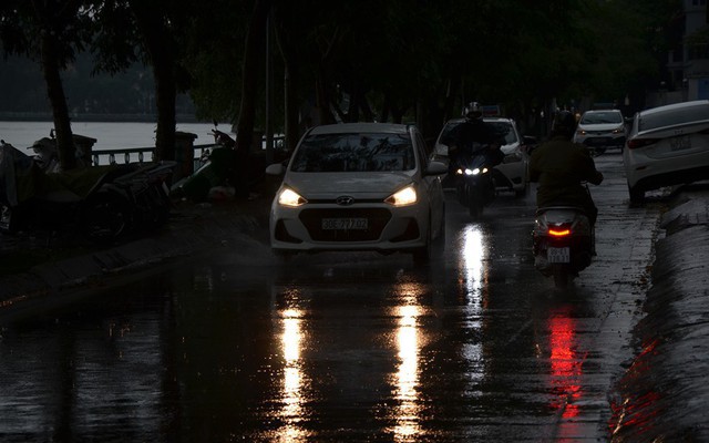 Trời Hà Nội tối đen trong cơn mưa chiều, hàng loạt xe bật đèn lưu thông