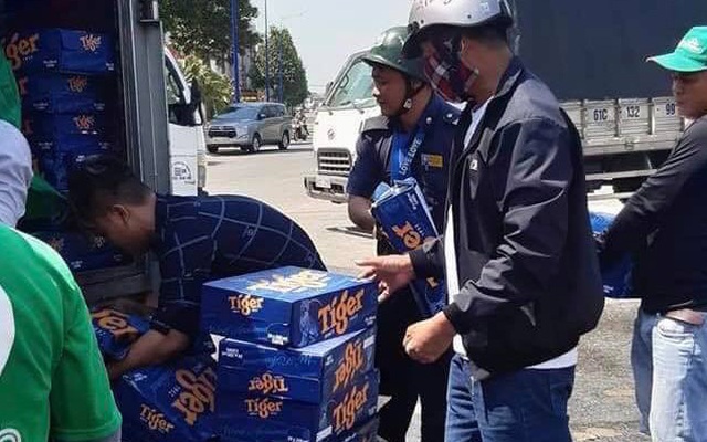 Hàng trăm thùng bia trên xe tải rơi xuống đường, người dân kéo nhau gom bia giúp tài xế
