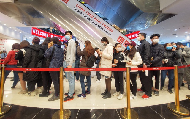 Hàng trăm khách đeo khẩu trang xếp hàng chờ mua sắm ở cửa hàng Uniqlo đầu tiên tại Hà Nội